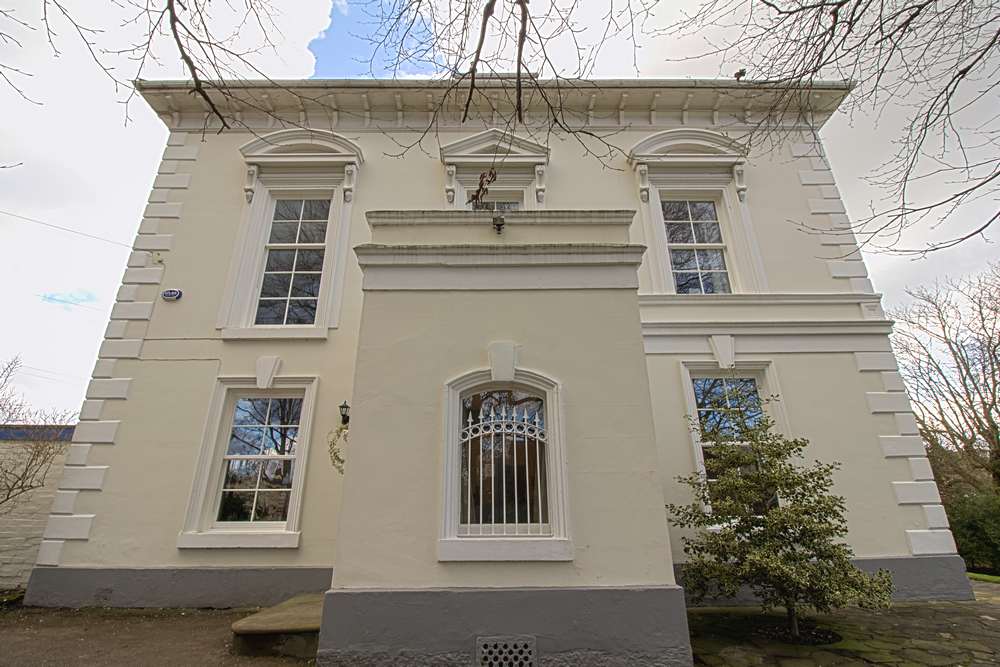 Close up of side entrance to property showing 5 extremely large sash windows with period correct glazing bars.