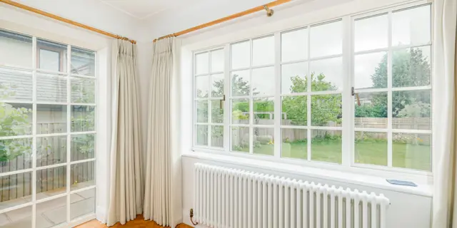 A large window above the radiator and another floor to ceiling window