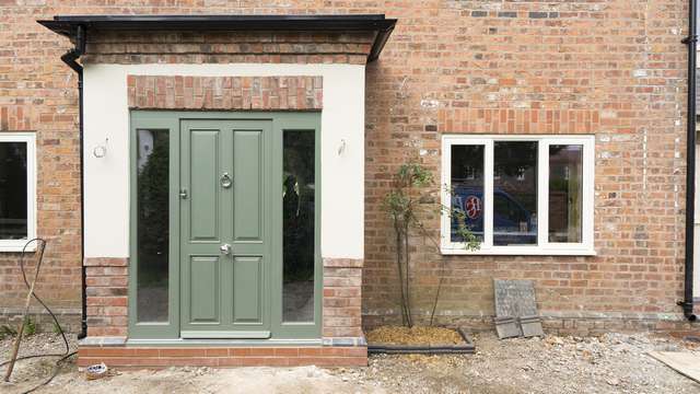 Traditional 4 panel entrance door with Chrome hardware and glass sidelights.
