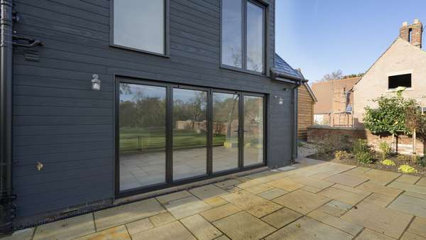 External view of the black aluminium bifolds installed in Cheshire.