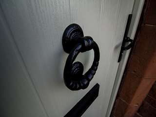 Traditional cast iron effect door knocker and other door hardware.
