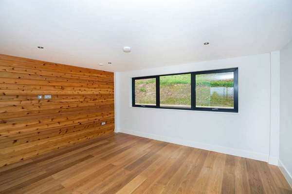 Internal living space with feature aluminium window and wood panelling.
