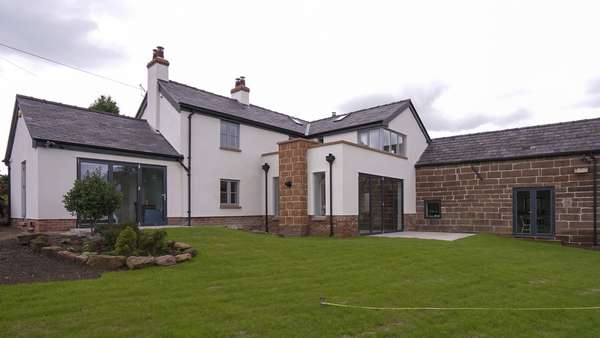 The rear of the home looking its best, with the two differetn building styles and glazing schemes.