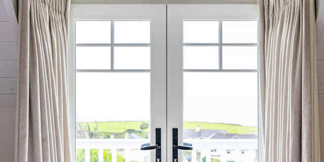 Bedroom pation doors looking through to the balcony over village