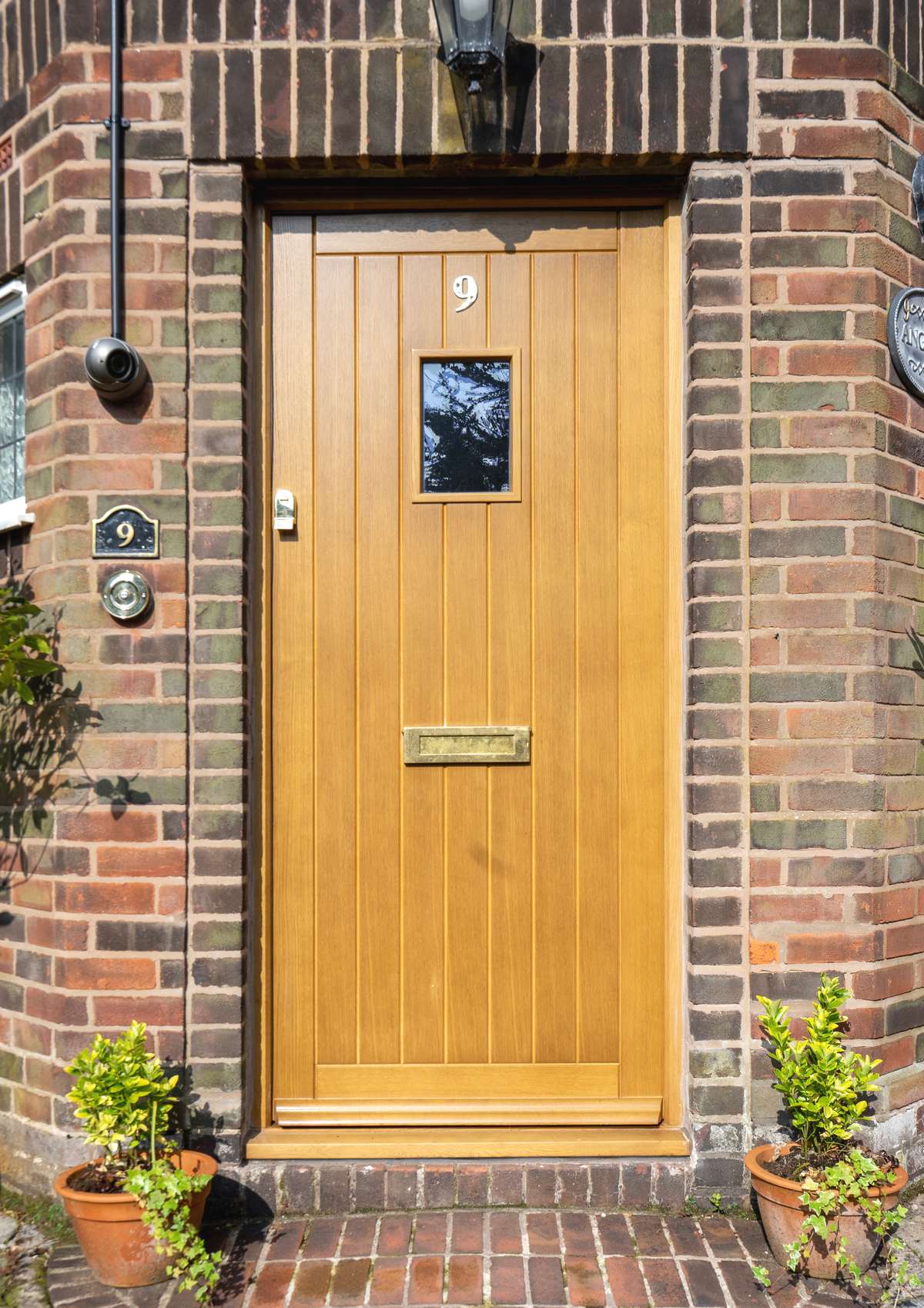 Solid oak entrance door with brass hardware.