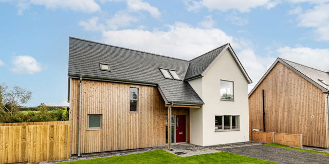 Front of new build property with render and wood cladding