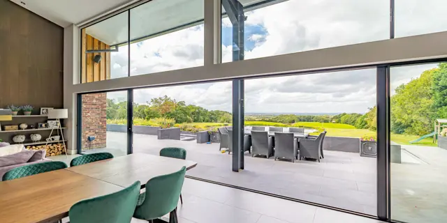 Looking through the sliding doors onto garden terrace with dining table in view