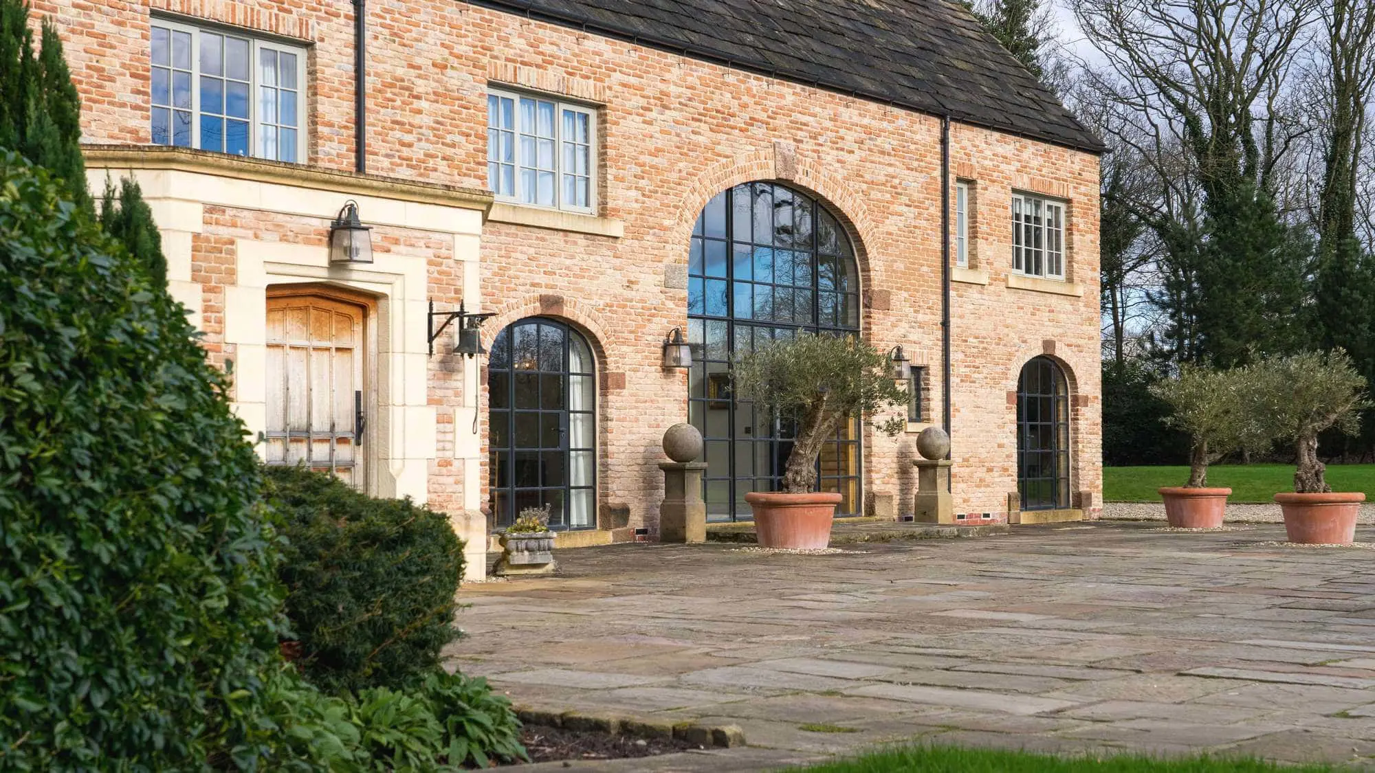 New build French Farmhouse in Cheshire featuring a full glazing scheme including arched Crittall screens and timber windows.