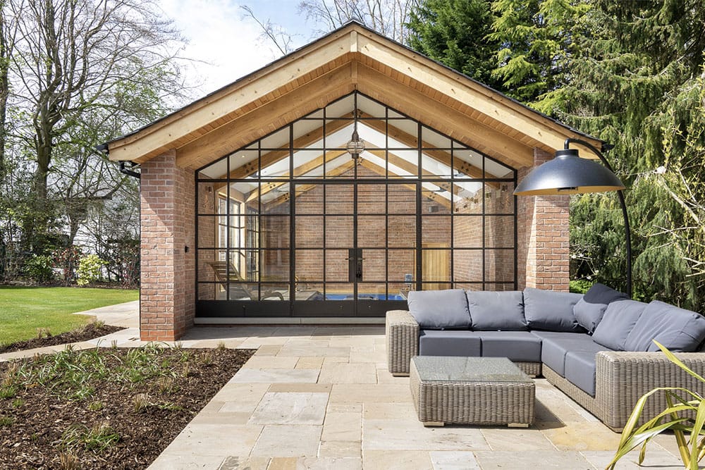 Traditional pitched garden room with Crittall screen and pool.
