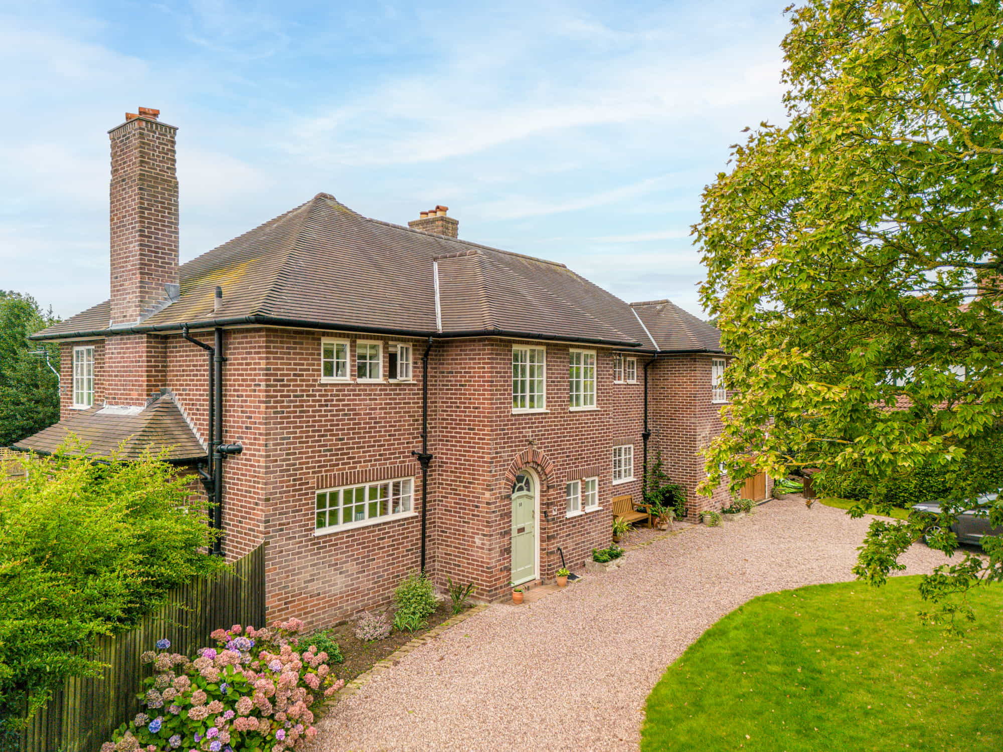 Drone shot of red brick house with gravel pathway