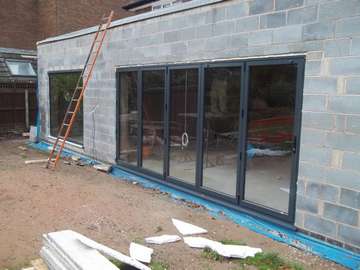 Installtion in Liverppool woolton area of our Allstyle Bi folding door system with a large Alstyle fixed window. the large panel is constructed of 8mm double glazed Toughned glass. low E soft coat glass. Argon gas filled
