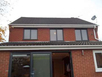 Rear elervation picture of a replacement installtion from PvcU white windows to 7016 grey Alumninium windows