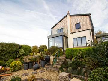 External shot of refurbishment project in Heswall Wirral. Full installation of Alu-clad windows and doors and glass balustrade.