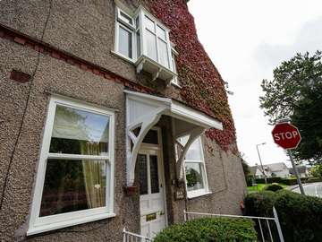 View of sliding sash windows and UPVC casement bay window with corner posts.