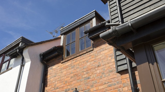 Brown alu clad window close up with astregal bars.