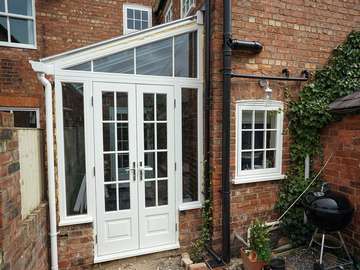 Custom design lean to consevatory with timber french doors and side lights and aluminium roof. All glazing is double glazed, the timber doors and windows are from our own Knight Collection and the roof is from our bespoke roof light system. 