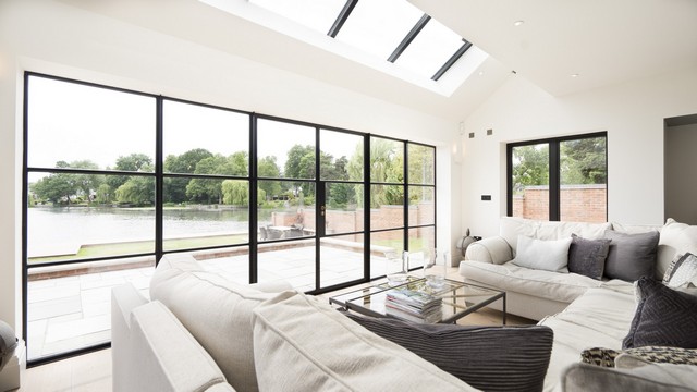 A bright living space making best use of the lake, viewed through a large set of Crittall doors, extra light added through the rooflight.