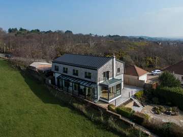 View of the completed project in Wirral, showing Internorm aluminium clad timber lift and glide doors, sunflex bifold doors and bespoke aluminium & glass viewing gallery.