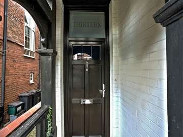 Black timber effect door from the English Door Company with chrome hardware and feature glazing with house number etched in with a sand blast finish.