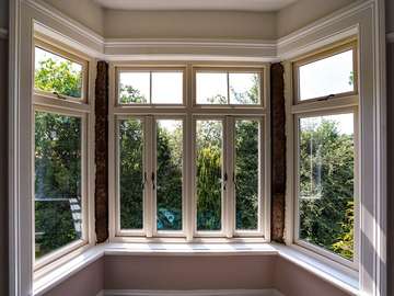 Internal view of Evolution timber look windows in cream with woodgrain affect. The windows feature cast iron black handles to further enhance the look and imitate the traditional style of original timber windows.