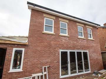 Rear view of new build house in Formby, Liverpool featuring UPVC casement window, UPVC sliding sash windows and aluminium Centor bifold doors. All windows and doors supplied in white to ensure a consistent look throughout the home.