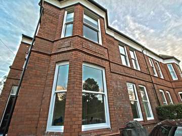 Front view of Victorian property showing large sash window installation.