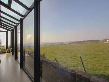 Making the most of the view from this bespoke aluminium gallery.