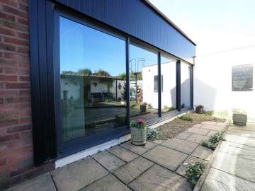 Dual sliding door in aluminium finished in grey RAL 7016.