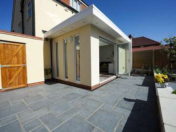 Corner view of this stunning orangery build, feature slim vertical windows can be seen here giving an alternative modern look over traditionally shaped casement windows whilst maximising on light throughout the day.