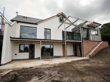 Rear view of full house Rationel window and door installation in Neston, Cheshire. Windows are a dual colour with Grey RAL 7016 externally. All windows and doors are alu-clad timber fitted with triple glazing for added energy efficiency.