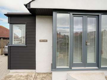 Close up of Rationel french doors with side lights and feature black clad property extension with stunning corner windows to maximise on the sea view.