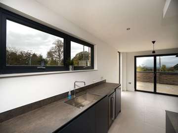 Internal view of aluminium windows and bespoke kitchen.