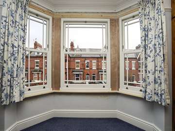 Internal view of recently fitted sliding sash bay window. Three individual sash windows have been installed to complete this bay window in Chester. The windows supplied feature a margin border style astregal bar configuration adding to the overall impact of the windows.