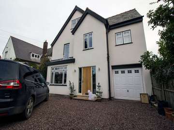 Evolution timber alternative windows in dual colour with black wood grain foil finish frames and white windows.