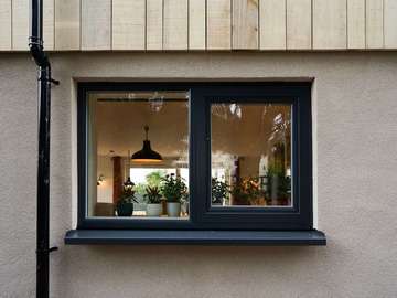 Kitchen window from Rationel in white timber with grey alu capping. Window features a signle opener and side glass.