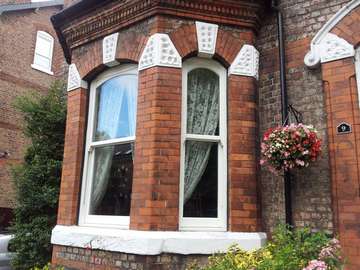 Mr B. : Sale Manchester - Insatlltion of Bygone melody Whitewood foiled Vertical sliding windows. Double Glazed with "A" Rated certification . Note Run through Horns . Large Bottom rial and bespoke arched head to match existing timber frames 