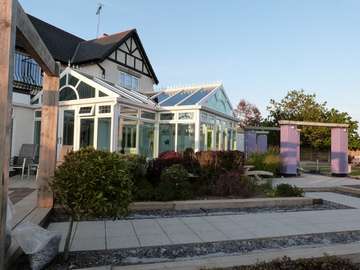 Caldy Wirral : Design and build - White PvcU conservatory construct from Deceaninck white PvcU doors and windows glazed with units constructed from Pilkington K glass / Pilkington Green Anti - sun. The roof is a K2a Aluminium Capped roof system glazed with Celsius clear units 