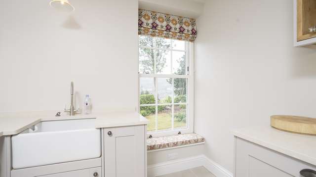 Internal image of a bygone sash windows installed as part of this utility room renovation, finished off beautifully by the client with a window seat and matching window dressing.