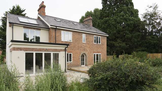 External view of the rear of this full house installation of Knight Collection timber windows and doors. All products are made to order including the very bespoke arched rear door and timber bifolds.