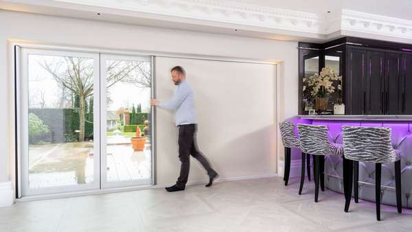 Model closing the integrated shade (blind) within the Centor bi-folding door.