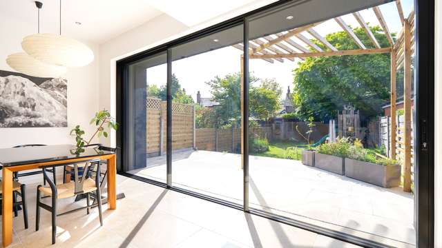 Angle view of the aluminium sliding door finished in black.