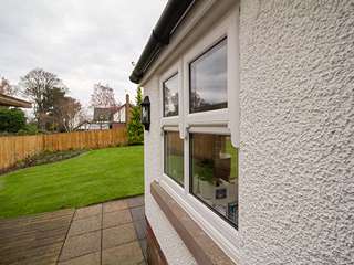 Dual mock sash UPVC windows featuring run through sash horns to imitate a sliding sash window.