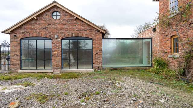 Straight on view of the two large crittall windows and glass corridor.