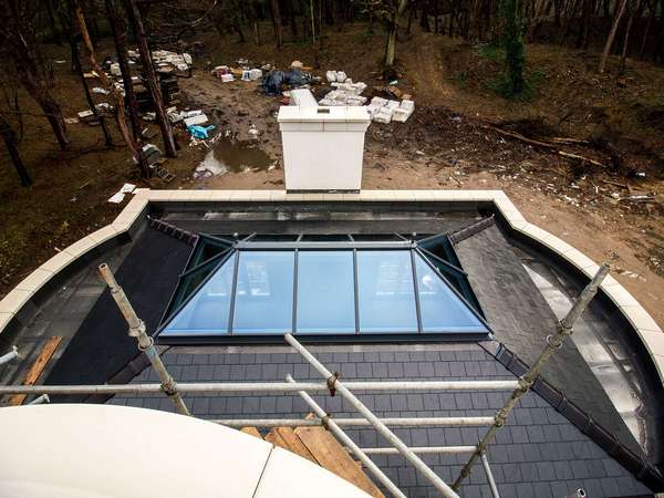 Grey aluminium roof lanterns in the centre of this double hipped roof maximising on light and making for a stunning design feature.