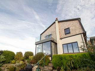 Alternative view showing the grey aluminium facade of the roofline, windows and doors creating a seamless look throughout the build.