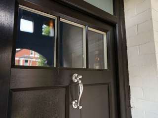 Feature door knocker and lighting on a traditional styled entrance door.