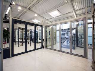 Dual sets of aluminium bifolding doors in light grey and Ral 7016 antracite grey.