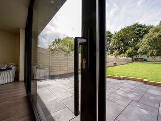 Aluminium door handle in black to match the finish on the door frame. Matching hardware gives a modern sameless look.