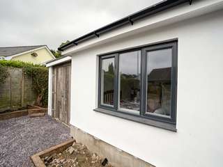 Close up shot of grey on white Rationel triple pane window with openers at either end, overall U value 0.91 with double glazing.