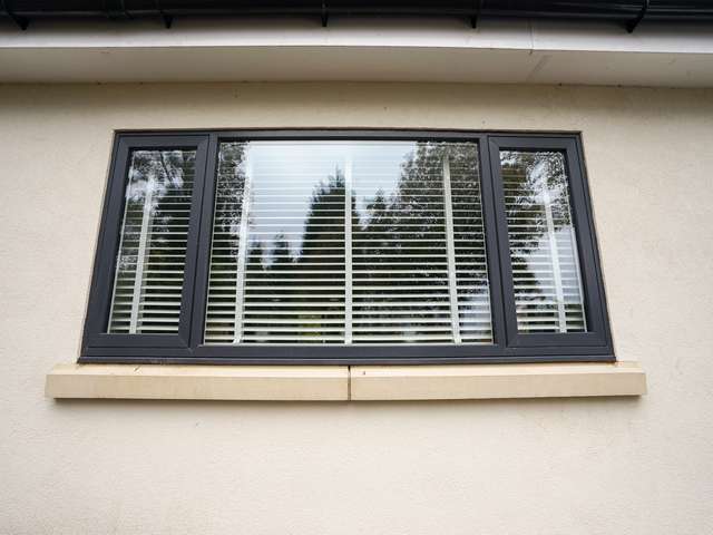 Grey flush casement window with feature cill.